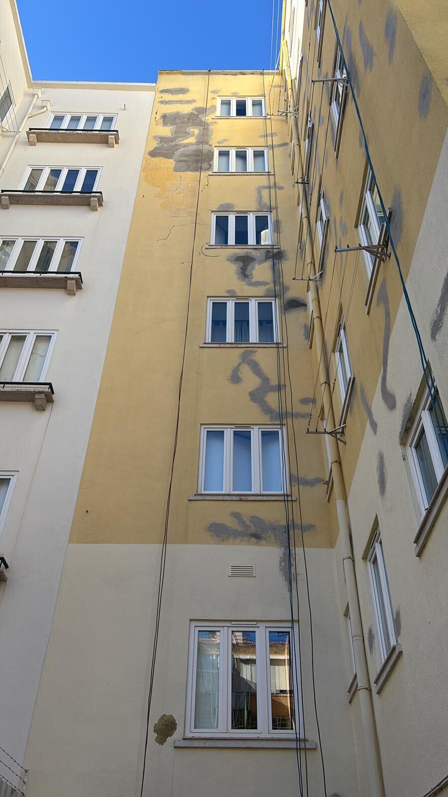 Fachada degradada com manchas e reboco a soltar antes da intervenção: Lisboa