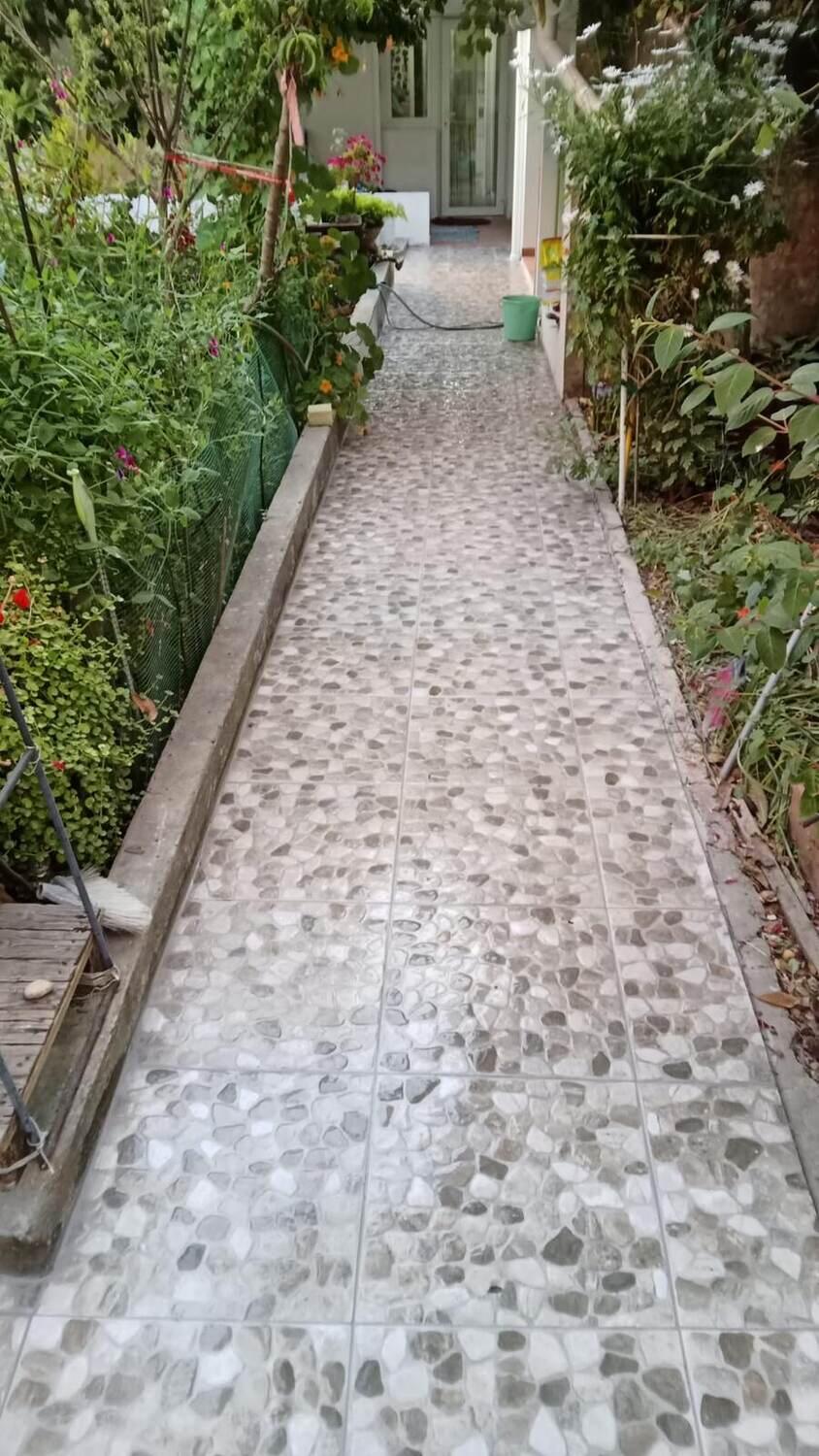 Depois: acesso exterior acabado, com pavimento novo e juntas fechadas