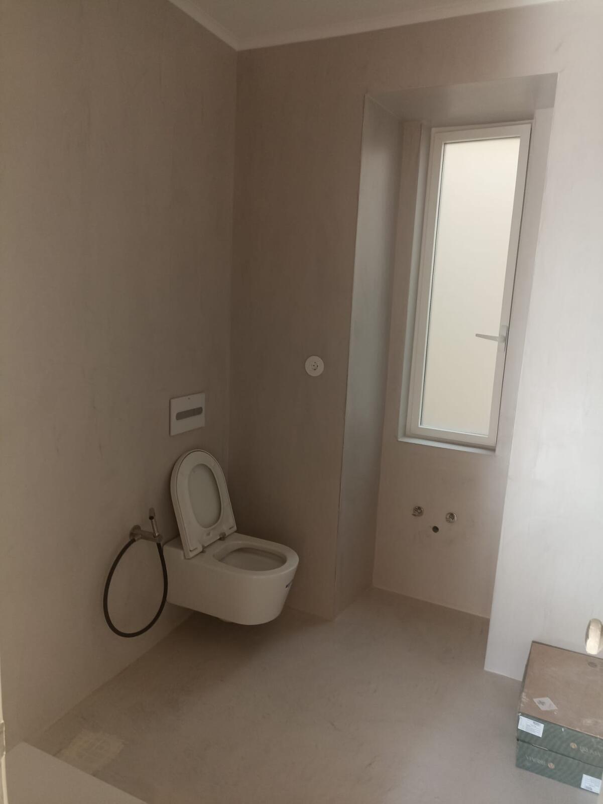 Casa de banho de serviço, com acabamento em cimento afagado