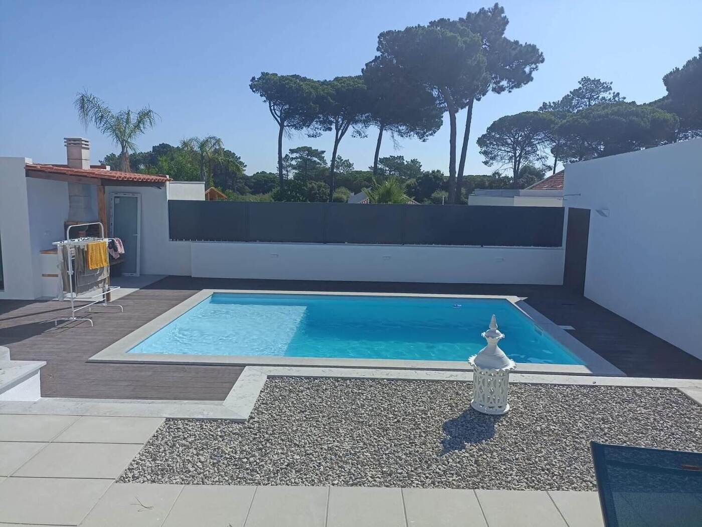 Piscina e zona de gravilha, com o pinhal em fundo
