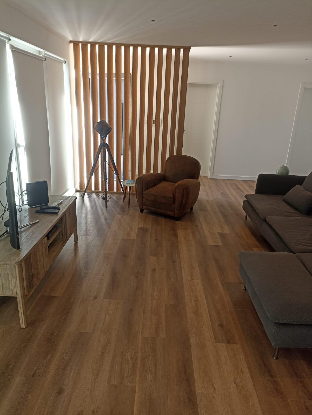 Sala de estar, separada da entrada por ripado de madeira