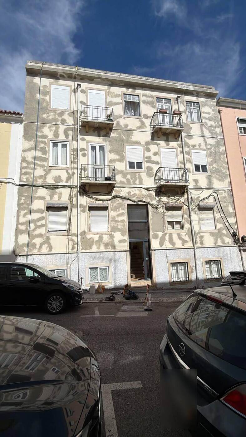 Fachada de prédio em Lisboa com a reparação pontual do reboco em curso | RJ Vertical